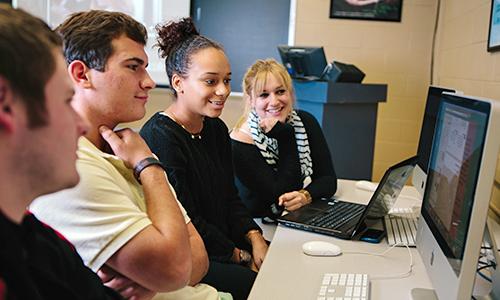 Students gathered around a computer screen